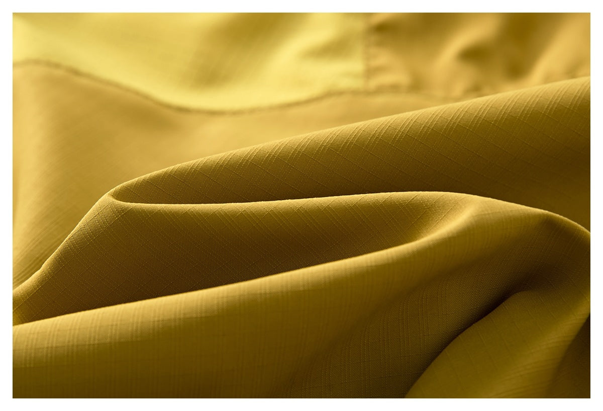 Macro view of mustard-yellow fabric folds showing a subtle crosshatch weave.