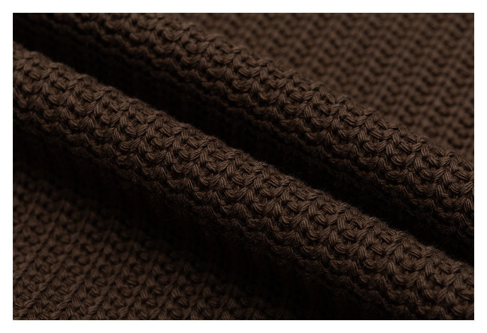 Close-up of dark brown knit fabric showing a chunky textured stitch.
