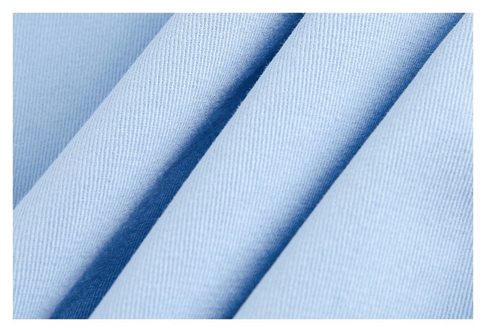 Close-up of light blue fabric arranged in soft folds, showing its fine diagonal weave.