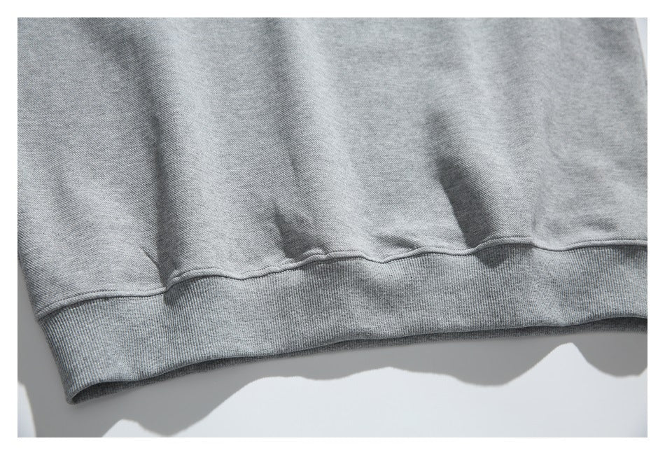 Close-up of the gray sweatshirt's lower hem and ribbed waistband.