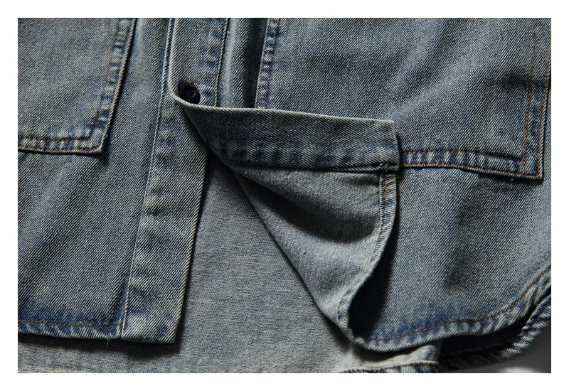 Close-up of a faded blue denim shirt with the front placket and pocket flap lifted to show the construction.