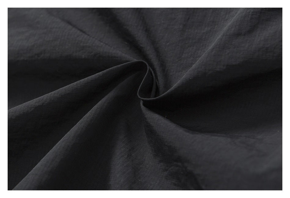 Macro view of dark fabric draped to show its subtle woven texture.