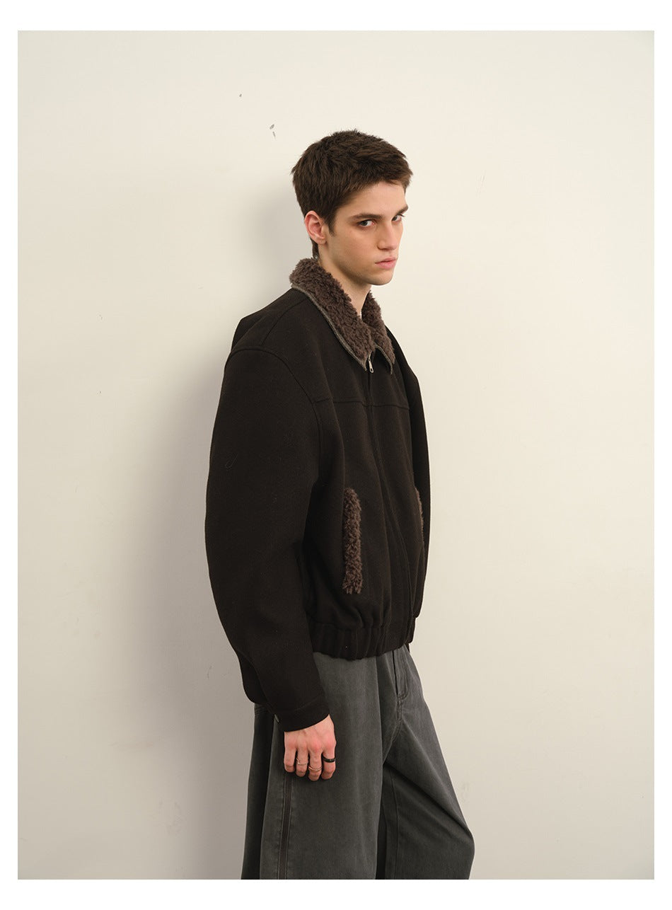 Side view of a model wearing a black jacket with a brown textured collar and pocket trim.