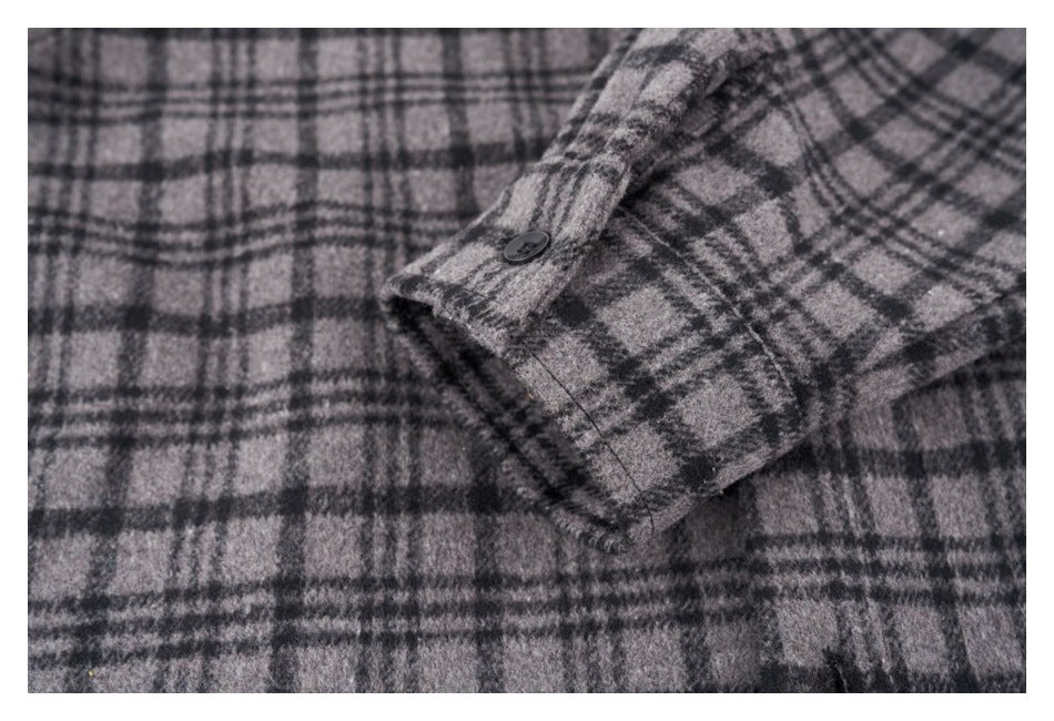 Close-up of a black button on a gray and black plaid cuff.