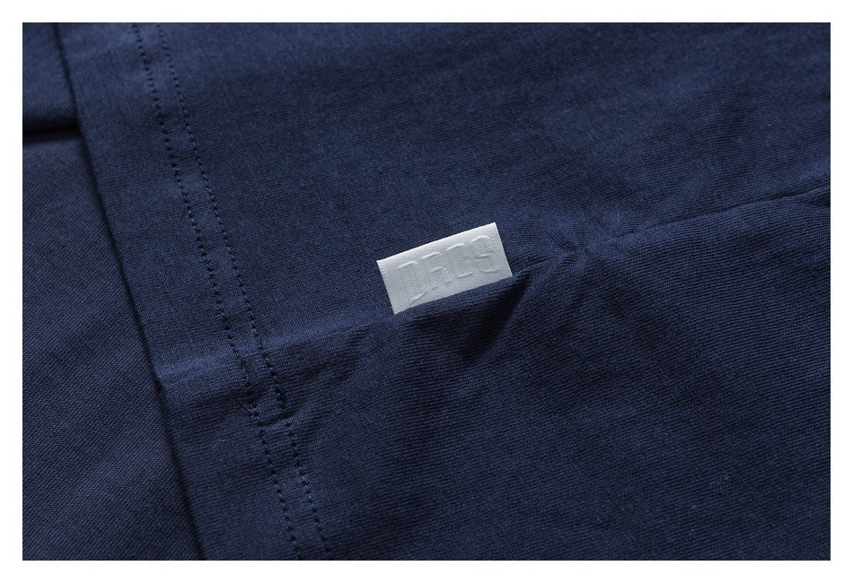 Close-up of navy fabric, a stitched seam, and a small white sewn-in label.