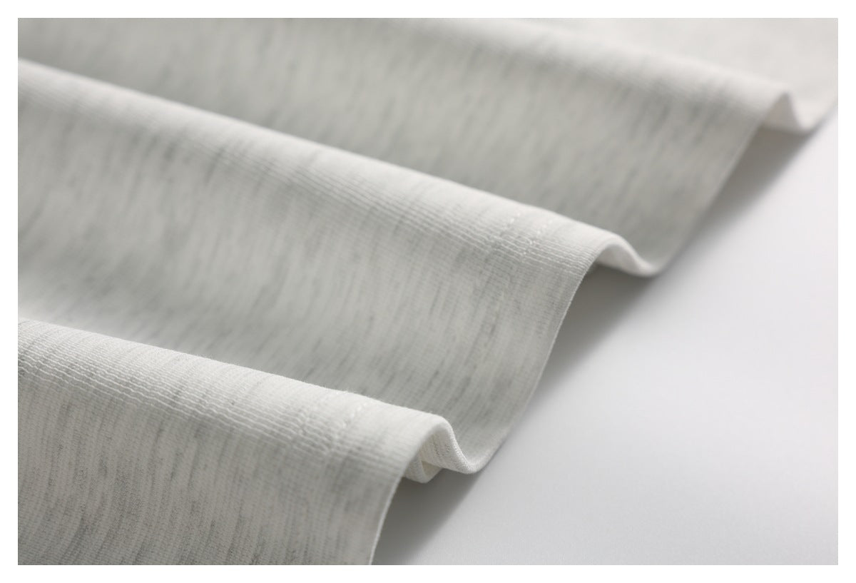 Close-up of light gray fabric folded to show its textured surface and edge.