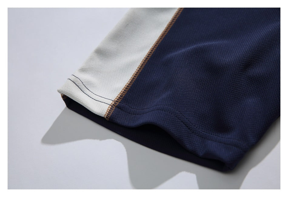 Close-up of the shirt sleeve hem, showing ivory and navy panels with visible stitching.