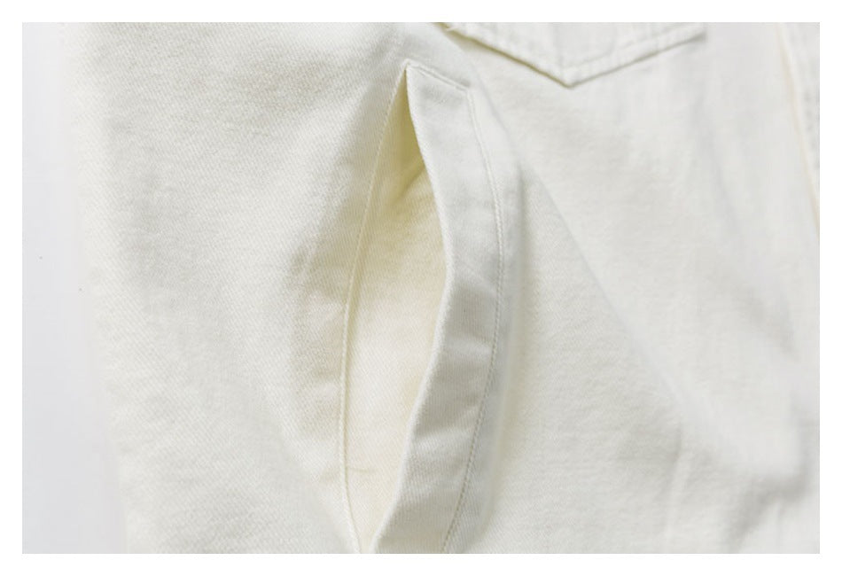 Close-up of an opening and stitched seams on an off-white garment.
