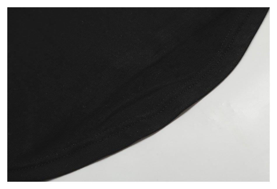 Close-up of a curved stitched hem on black fabric.