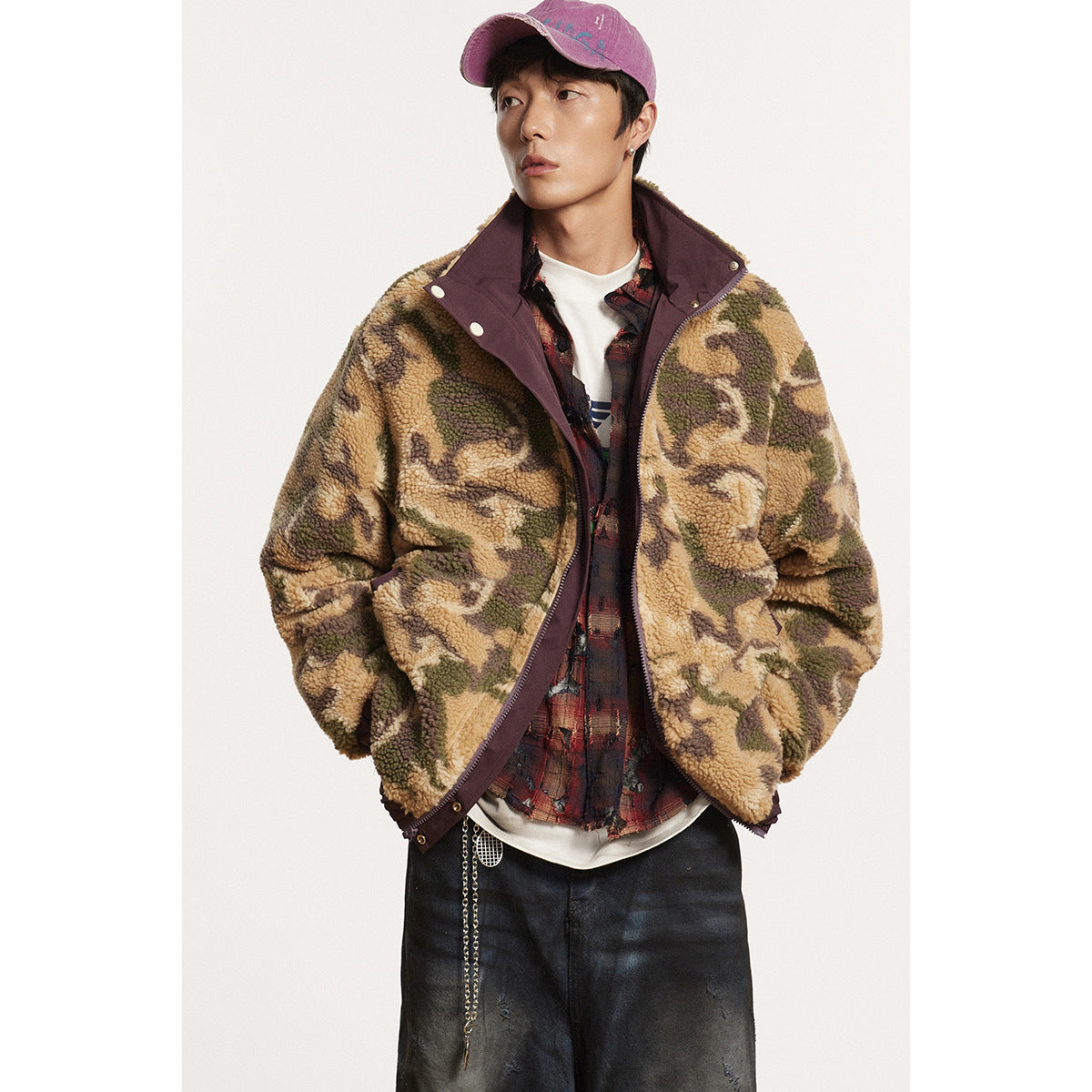 Model wearing a tan and olive camouflage fleece jacket with burgundy trim, layered over a plaid shirt.