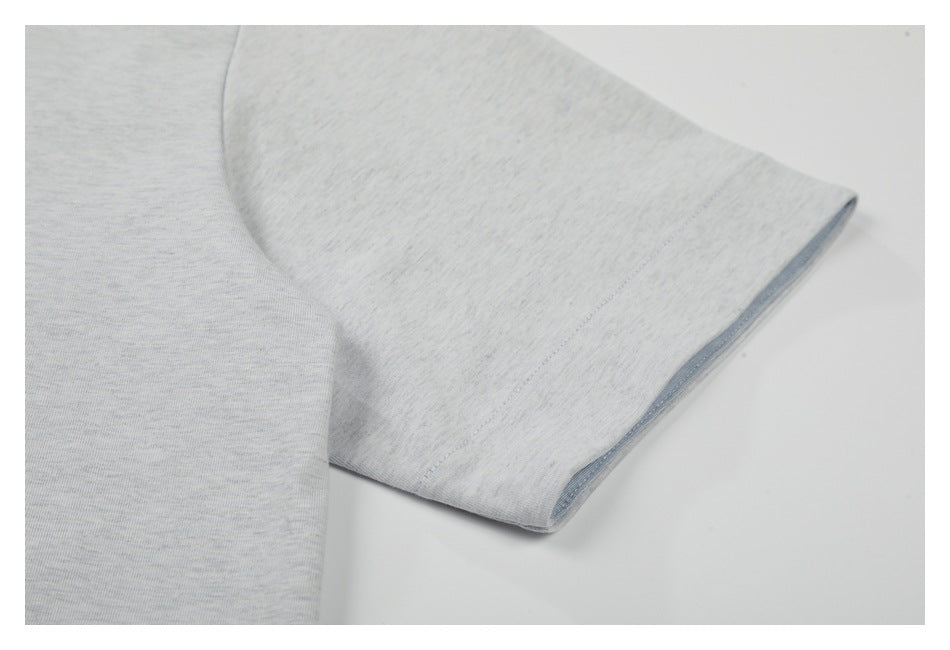 Close-up of a light gray T-shirt sleeve and stitched sleeve hem.