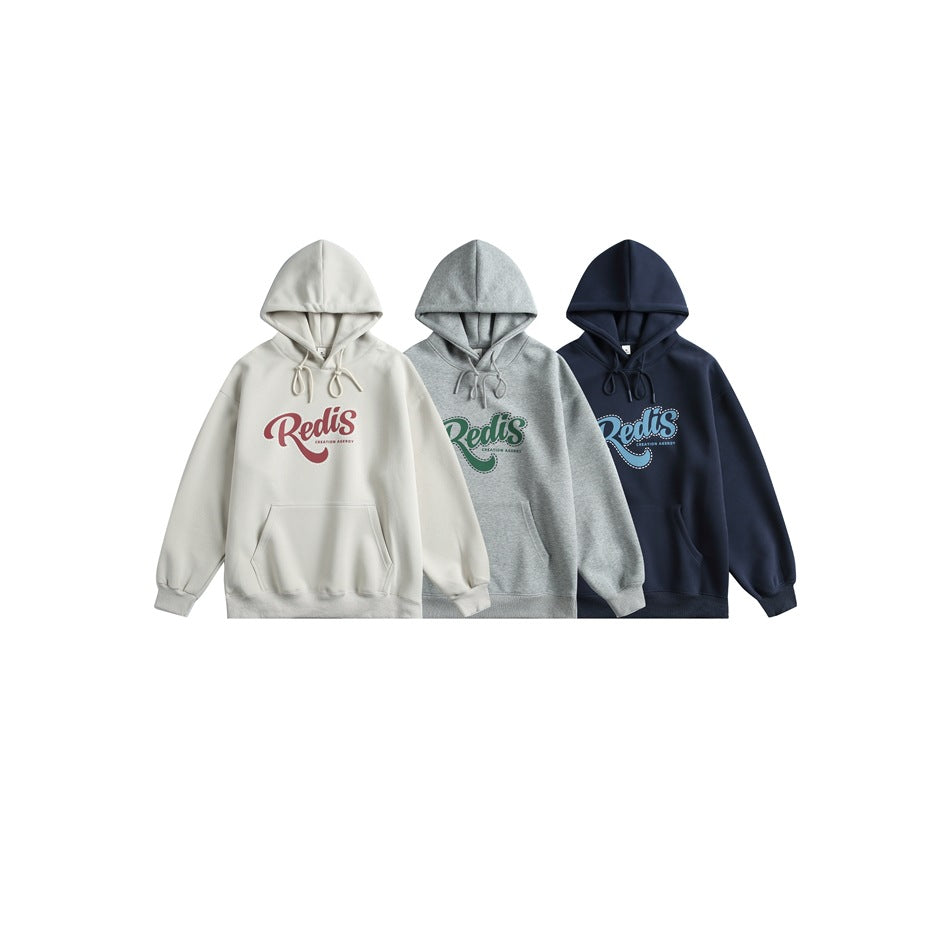 Three hoodies displayed side by side in cream, gray, and navy, each with a large colored chest graphic.
