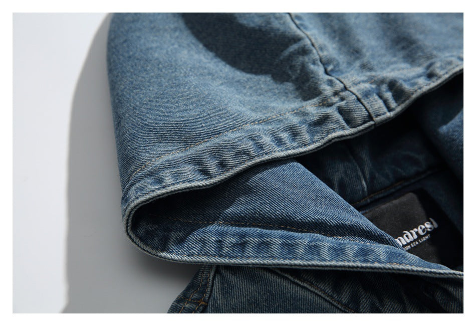 Close-up of the blue washed-denim hood edge and the jacket's sewn-in neck label.