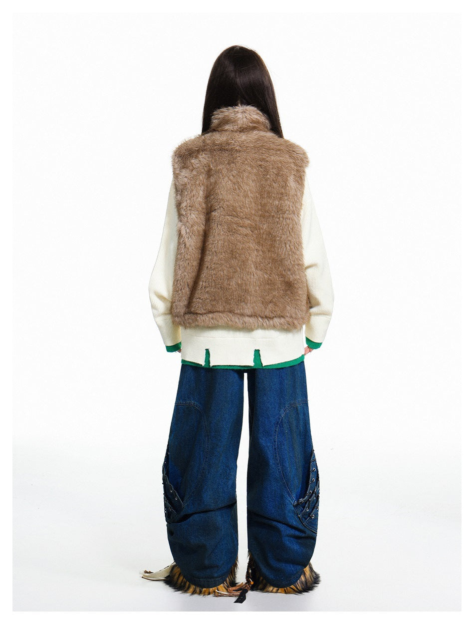 Back view of a model wearing a plain brown shaggy vest over an ivory sweater and wide blue jeans.