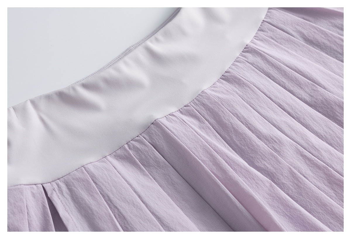 Close-up of a pale lavender skort showing the smooth waistband and gathered pleated skirt seam.