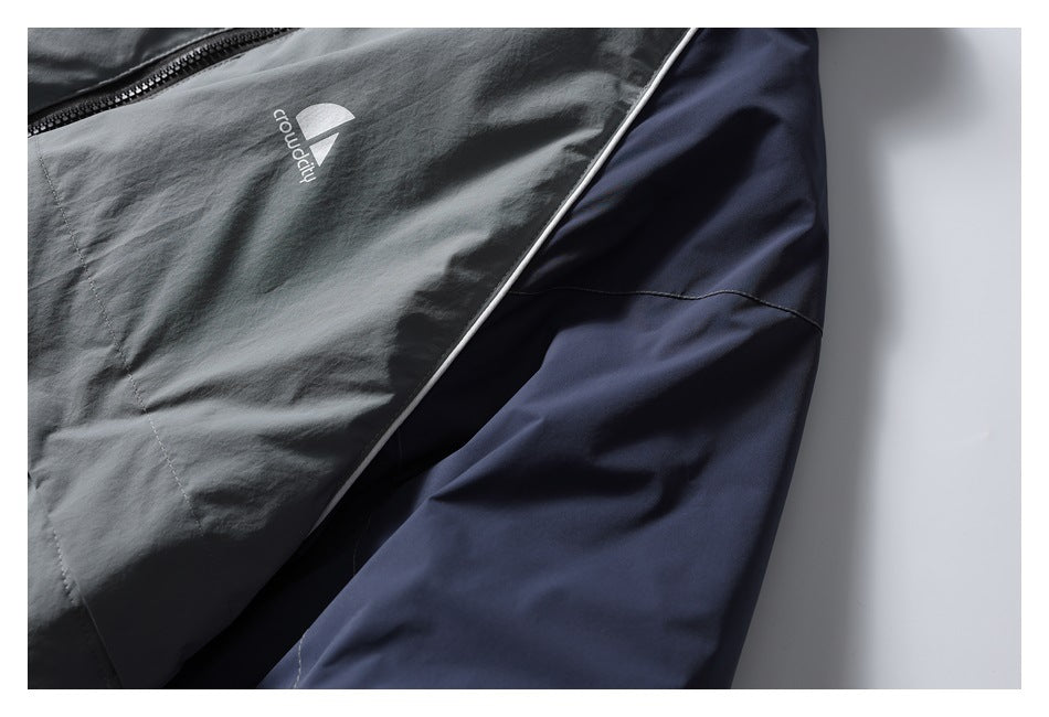 Close-up of the jacket's gray front panel, white piping, and navy sleeve.
