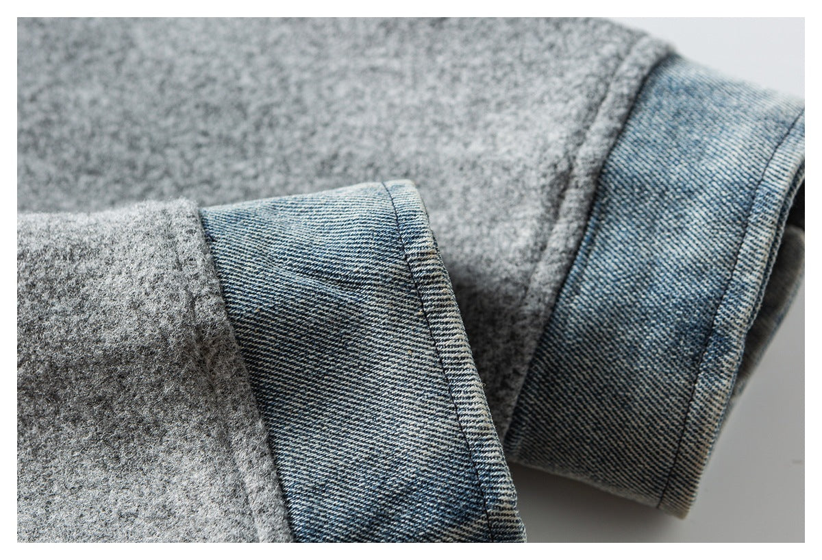 Close-up of gray coat sleeves showing blue denim-like cuff facings.