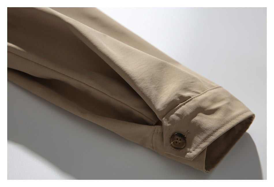 Close-up of a beige jacket sleeve ending in a buttoned cuff.