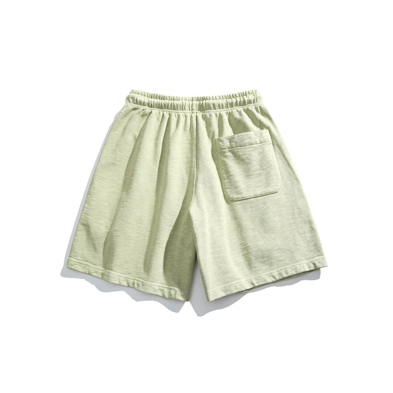 Pale sage shorts shown from the back, with an elastic waistband and a single patch pocket.
