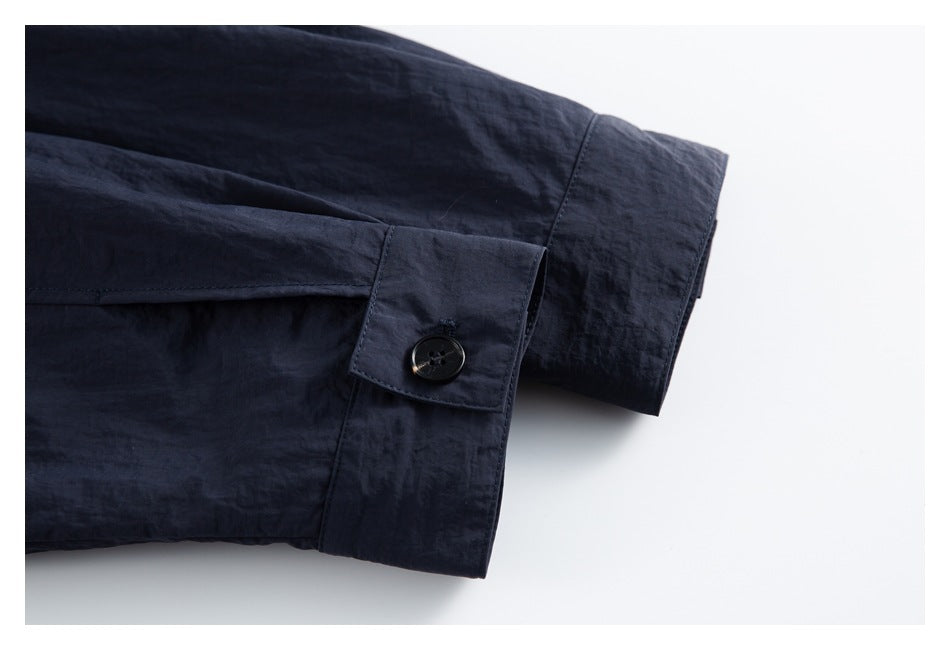 Close-up of a dark navy sleeve cuff with a single black button.