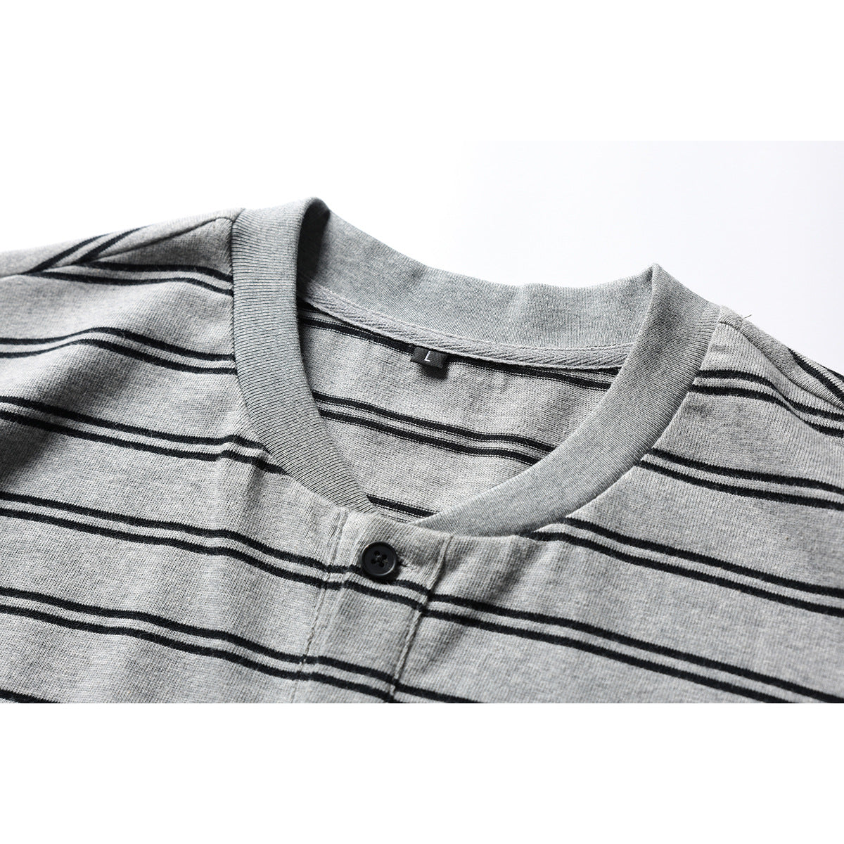 Close-up of a gray short-sleeve Henley shirt with thin black stripes, showing the ribbed neckline and button placket.