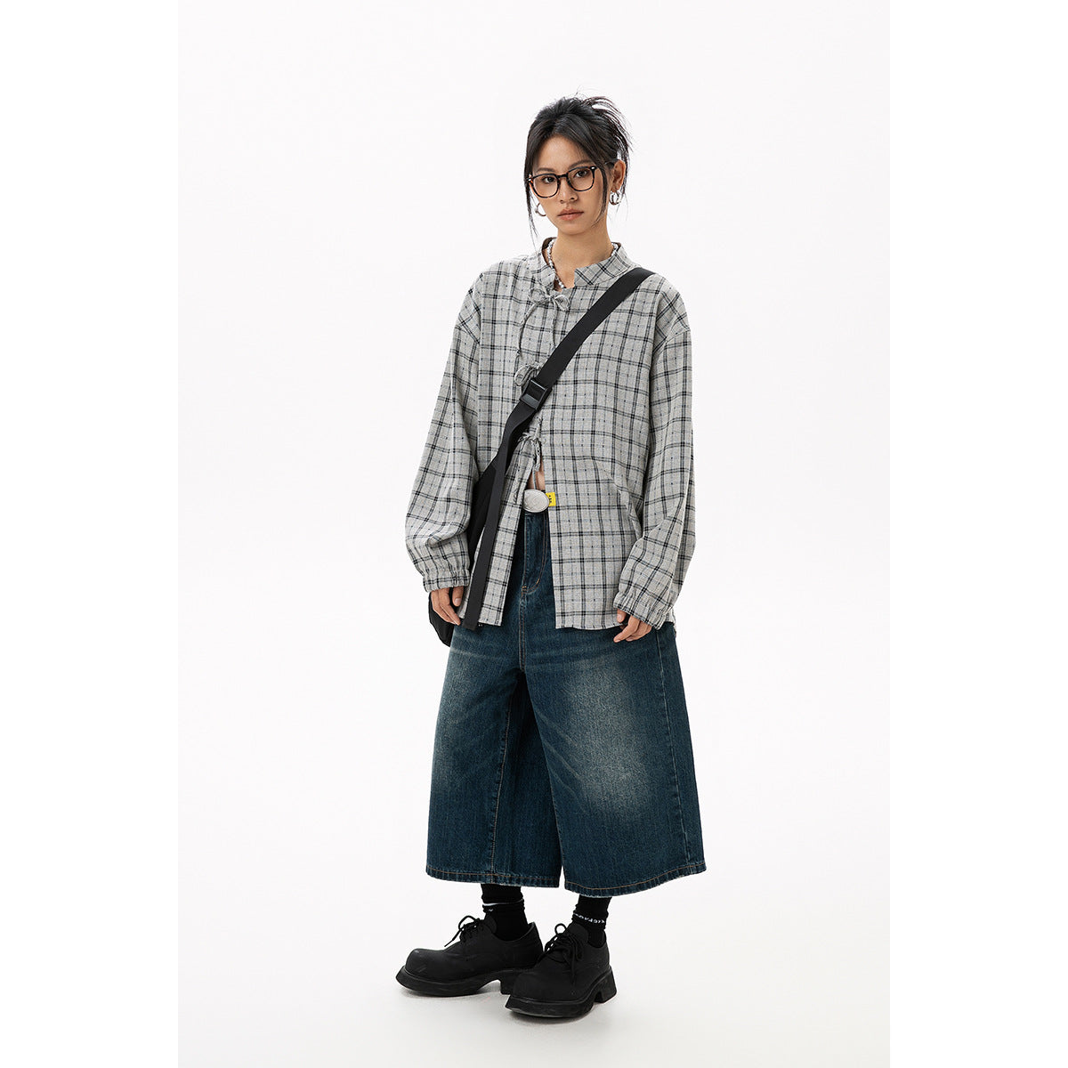 Full-length model wearing a gray plaid tie-front blouse with balloon sleeves and dark wide-leg cropped jeans.