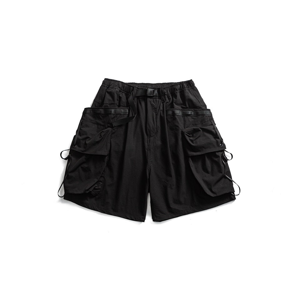 Black cargo shorts flat lay with buckled belt, large flap thigh pockets and side cord loops
