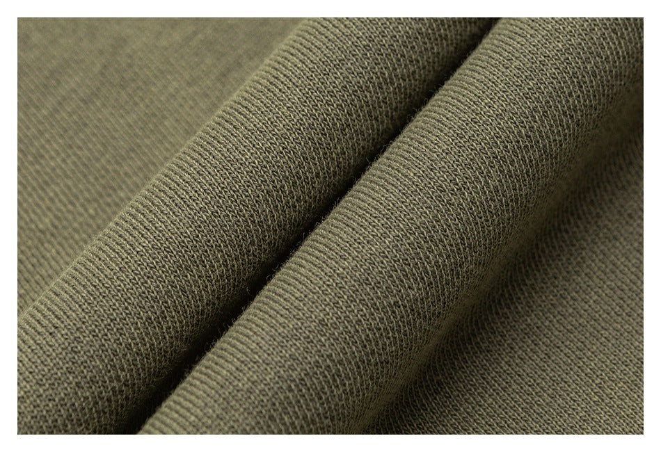 Macro view of olive green sweatshirt fabric folded to show its knit texture.