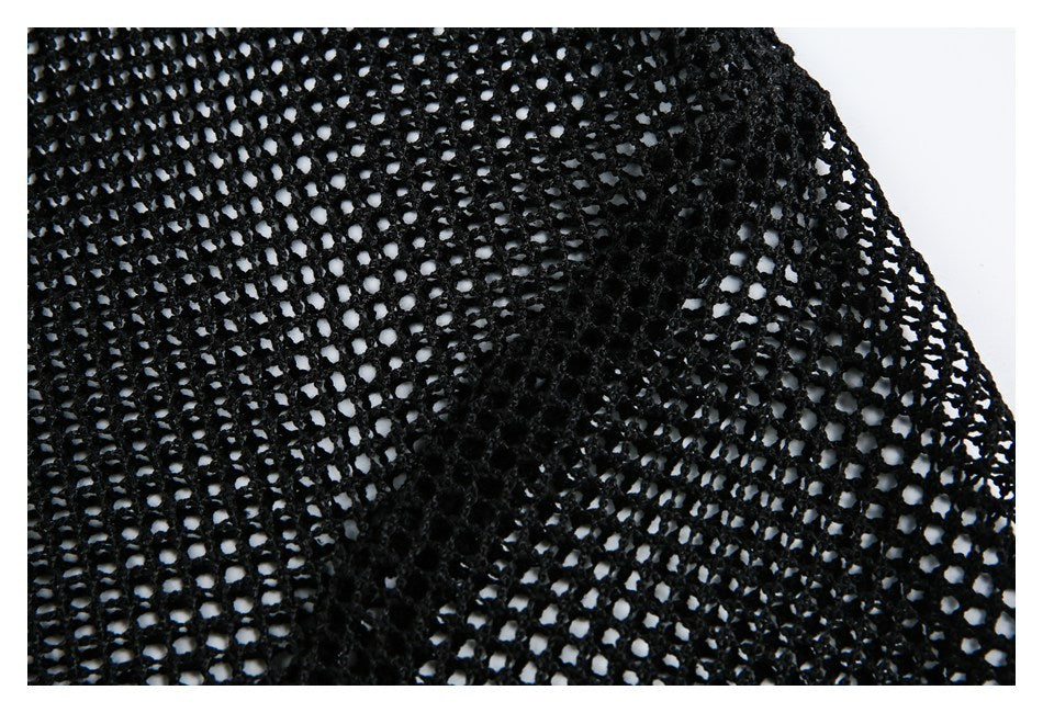 Close-up of black open-knit fabric showing a denser stitched panel beside a looser mesh area.