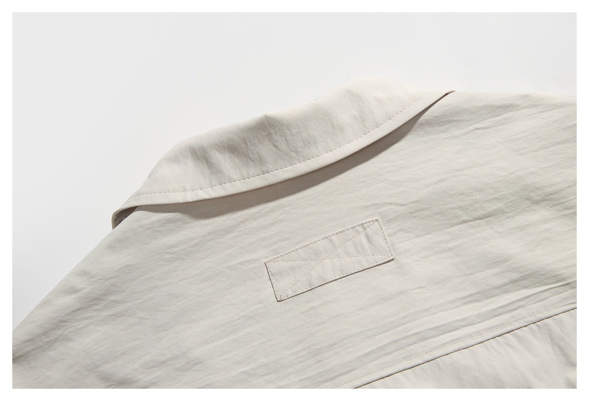 Close-up of a light beige garment collar and a small blank rectangular fabric patch.