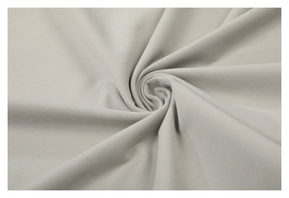 Close-up of light beige fabric gathered into a twist, showing its surface texture.