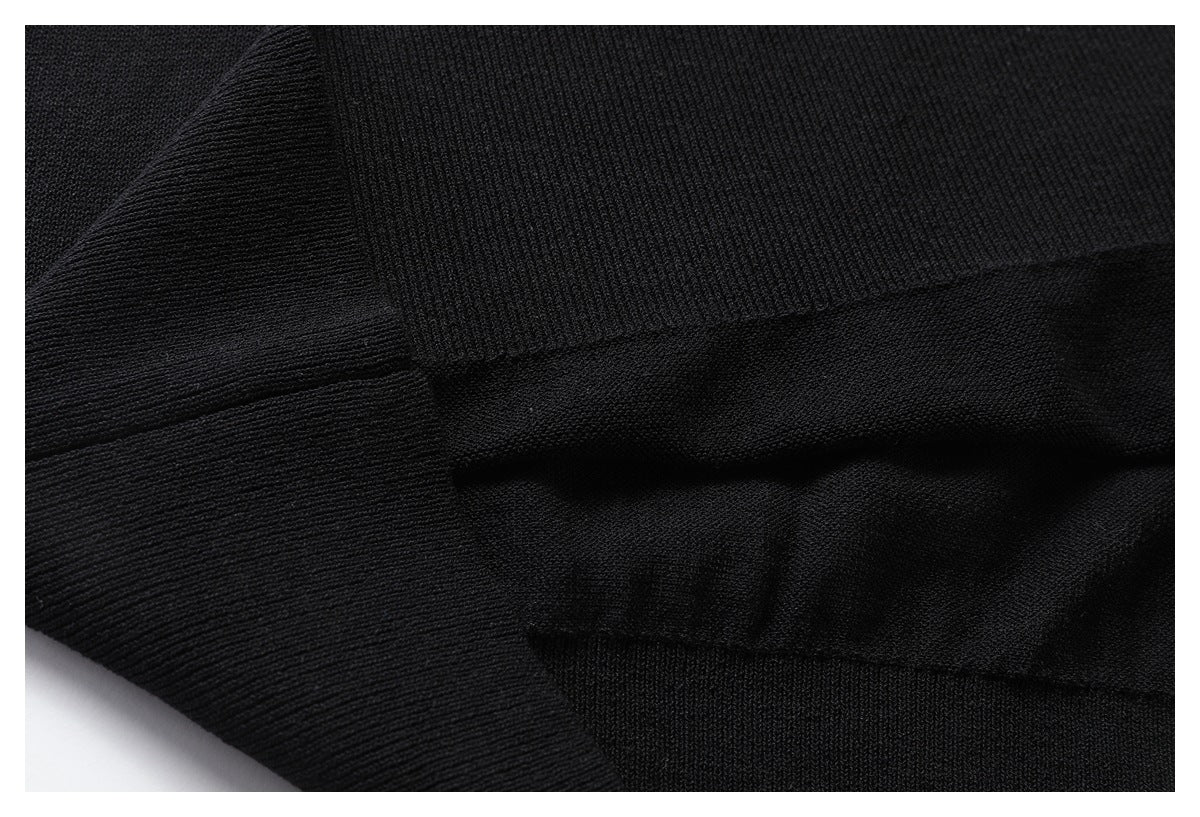 Close-up of black garment construction with a ribbed panel and stitched seams.