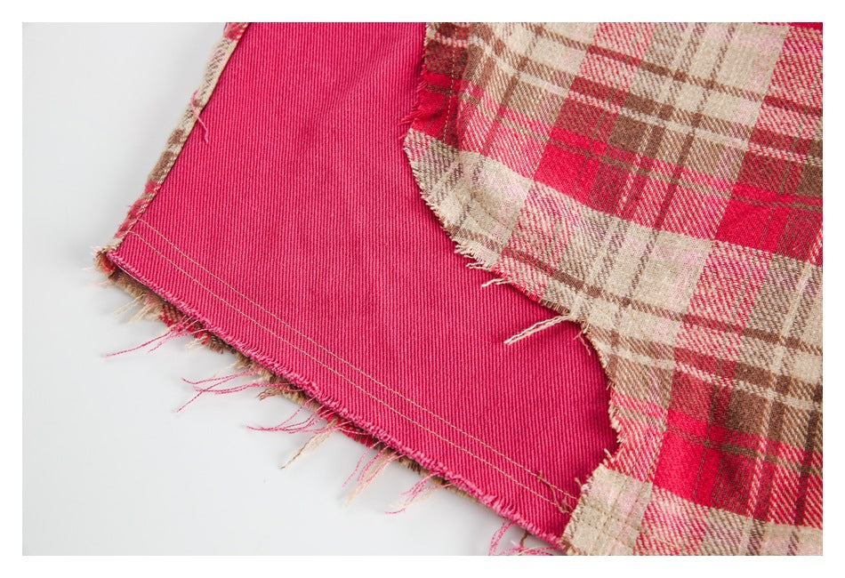 Close-up of the garment's frayed plaid edge and bright pink inner facing with stitching.