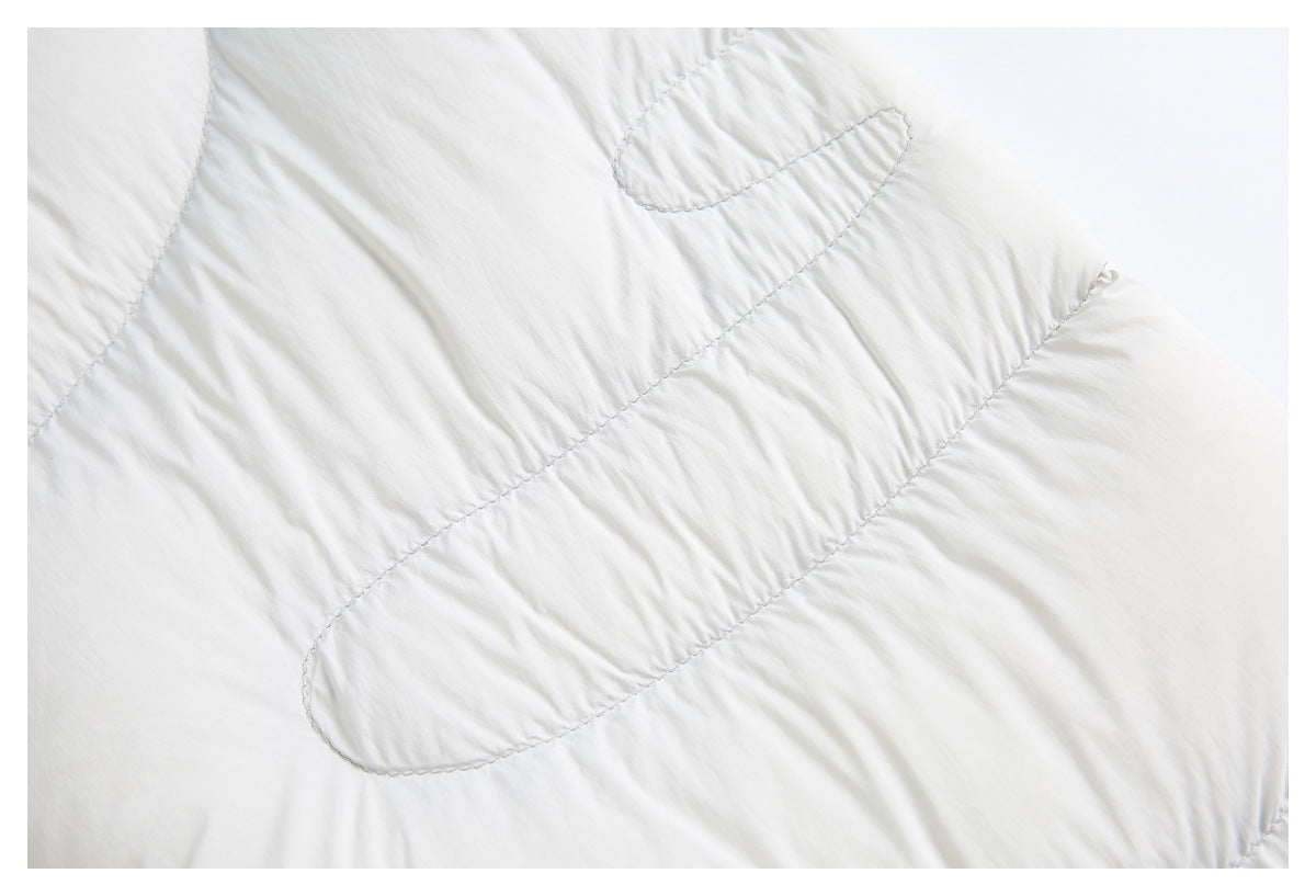 Close-up of curved quilt stitching on a light gray padded jacket panel.