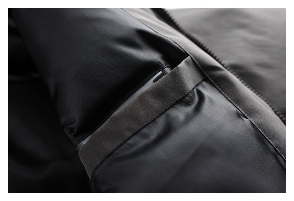 Close-up of a charcoal jacket's side pocket opening beside the front zipper.