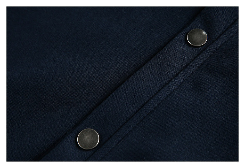 Close-up of two round metal snap buttons on dark navy fabric.