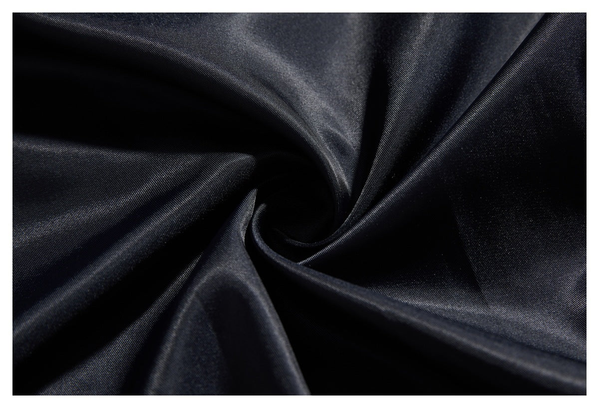 Macro view of dark, shiny fabric gathered into folds.