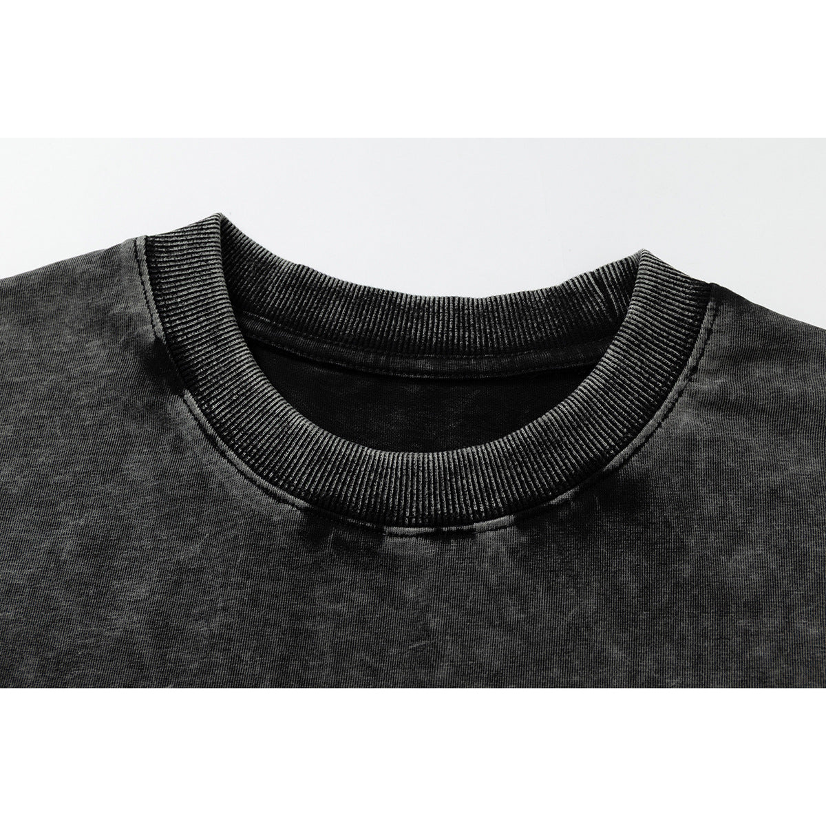 Close-up of a black acid-wash T-shirt's ribbed crew neckline and shoulder seams.