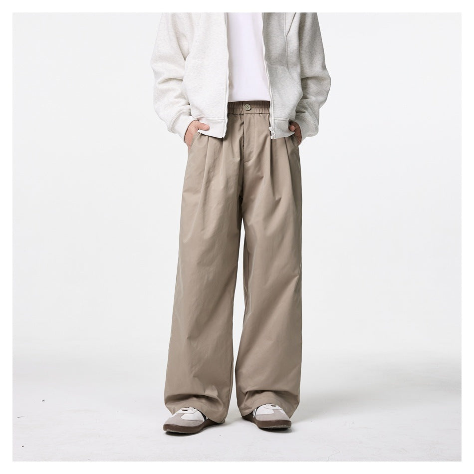 Cropped model wearing taupe wide-leg trousers with a buttoned, gathered waist, shown from the front.