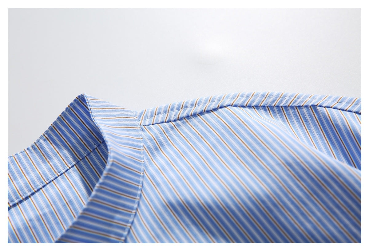Close-up of a blue, white, and tan striped shirt collar and upper body.
