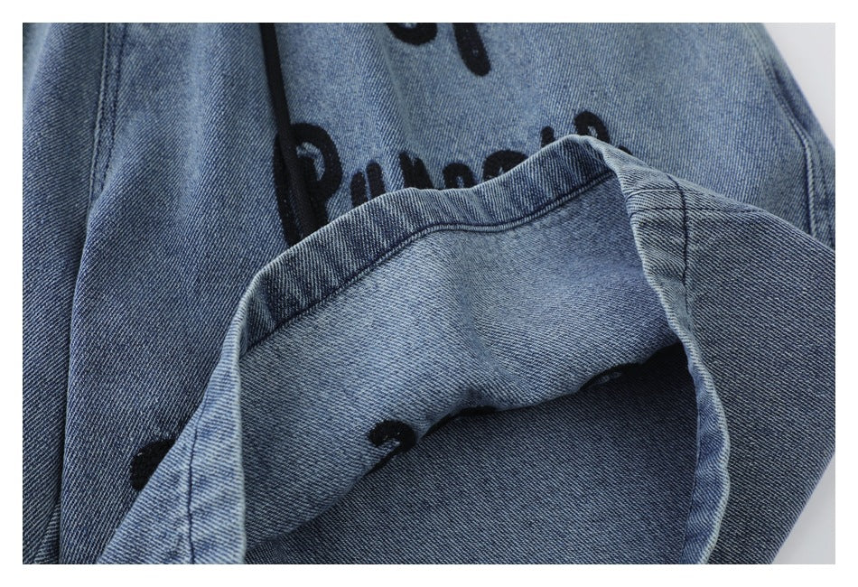 Close-up of a turned-up denim shorts leg showing the fabric underside and stitching.
