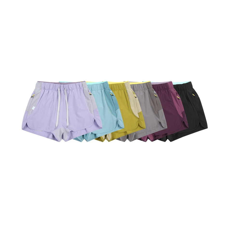 Six pairs of running shorts arranged together in lavender, light blue, yellow, gray, plum, and black.