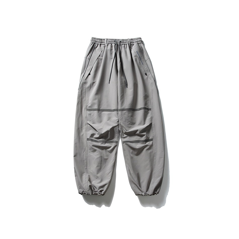 Light gray relaxed drawstring pants with gray knee stripes and gathered ankle hems, laid flat