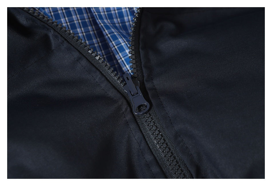 Close-up of a dark navy jacket zipper with blue-and-white plaid lining visible inside.