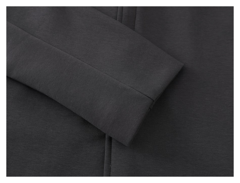 Close-up of a charcoal sleeve cuff laid across the garment, showing its stitched edge.