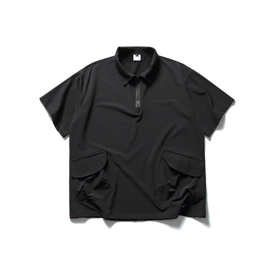 Black short-sleeve quarter-zip polo shirt with collar and two large flap pockets, laid flat, front view