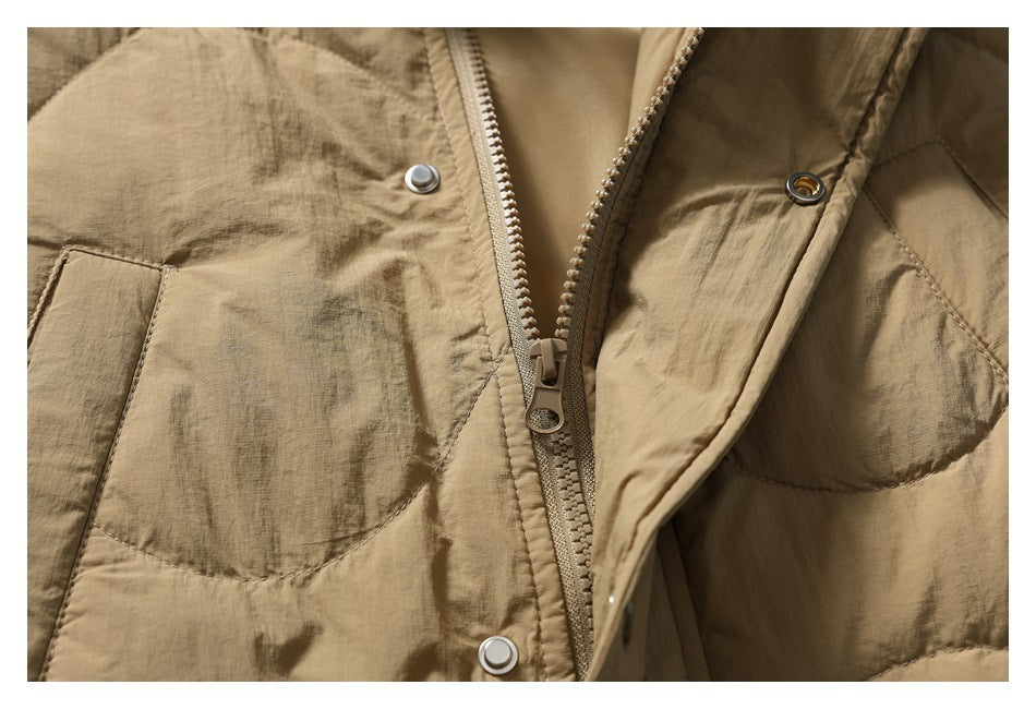 Close-up of the tan vest's open snap placket and zipper, with quilted panels on either side.