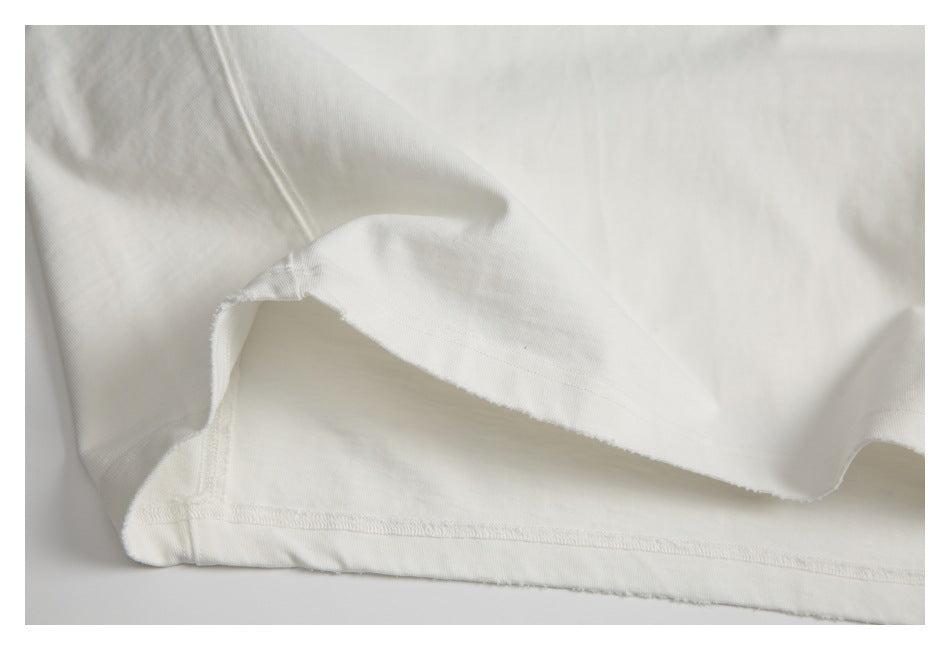 Close-up of the inside fabric and seam construction of an off-white T-shirt.