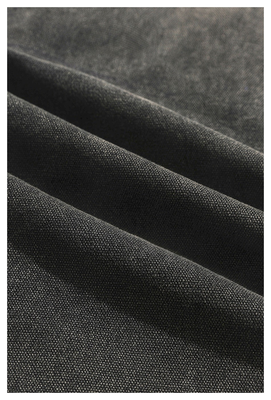 Macro view of charcoal fabric folded to show its textured surface.