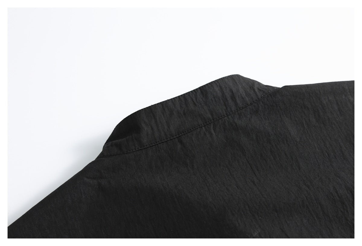 Close-up of the back shoulder yoke and collar seam on a black shirt.